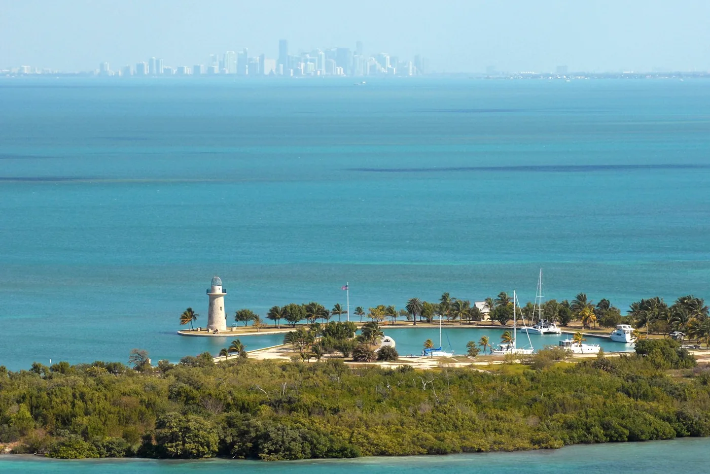 Boca Chita Key lighthouse and turquoise water, with Miami in the distance, in Biscayne National Park.