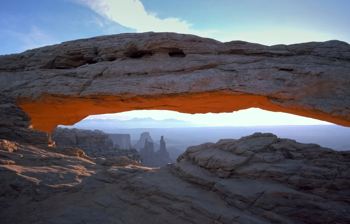 Mesa Arch framing distant rock formations in Canyonlands National Park.