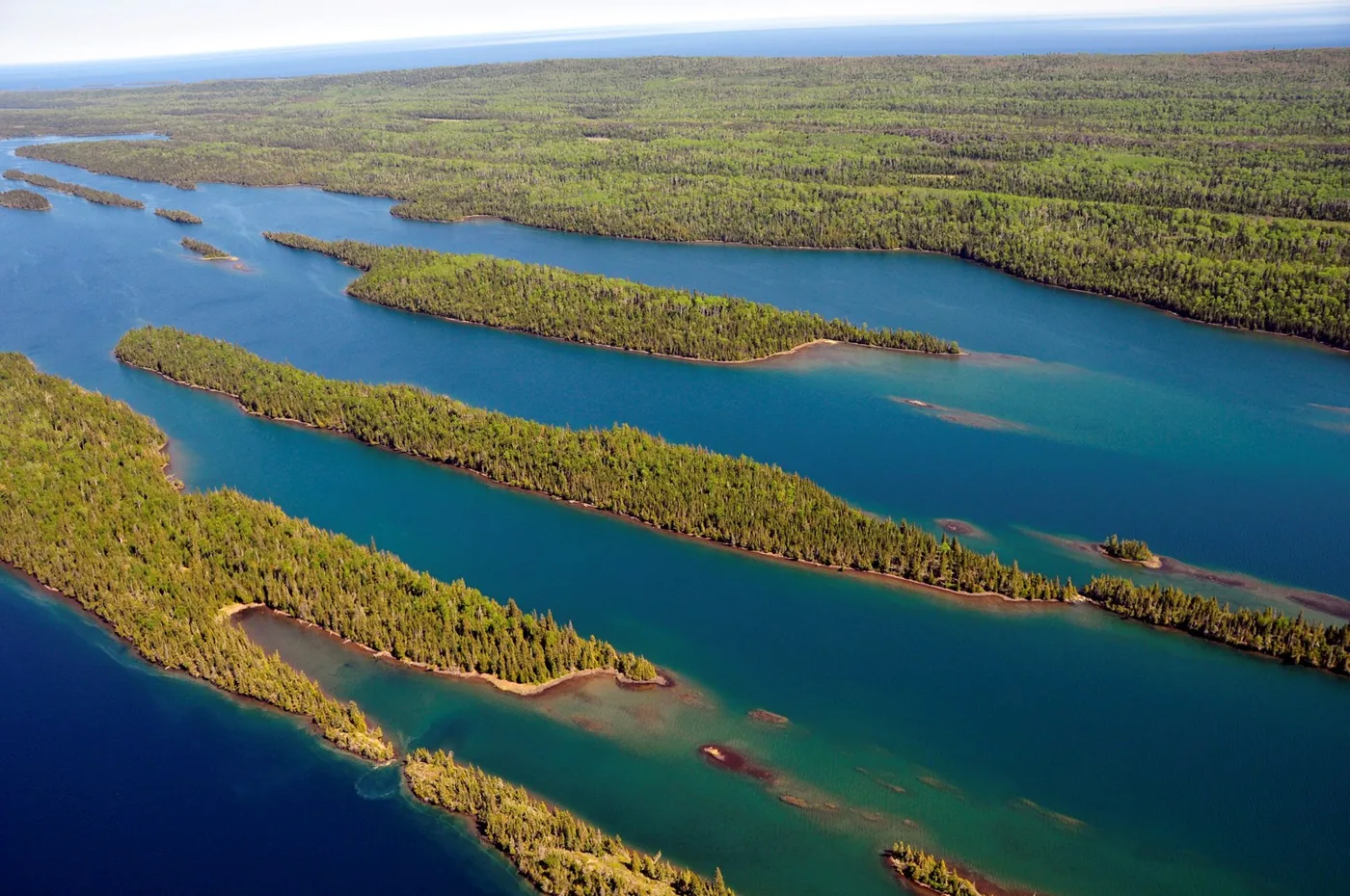 An aerial view of the forested islands and blue water of Belle Harbor in Isle Royale National Park.