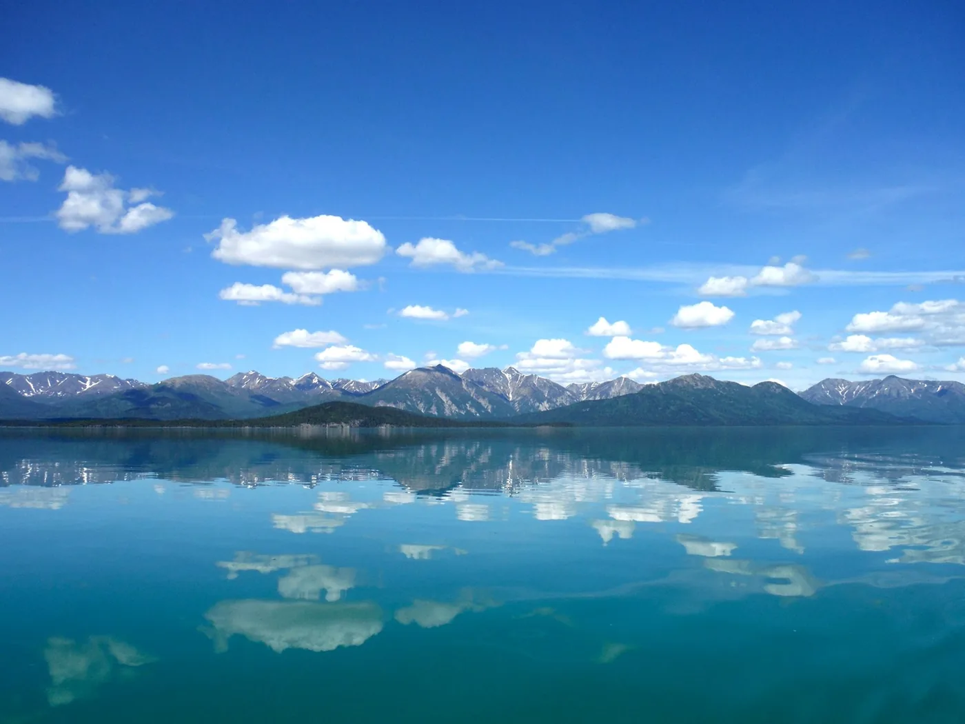 Mountains and clouds reflected in calm Lake Clark in Lake Clark National Park and Preserve.