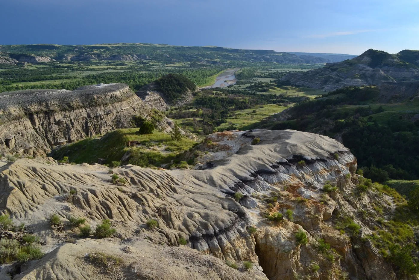 Layered badlands and green valleys seen from River Bend Overlook in Theodore Roosevelt National Park.